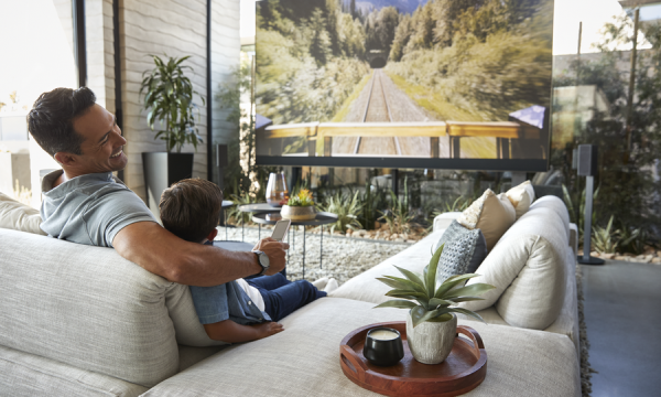 SODEVA_June_GlowBlog1_HomeAutomation_Roanoke-Lynchburg_VA_IMAGE A father and son watch TV in a brightly lit living room.